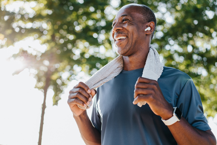 Man done working out with a towel around his neck. 