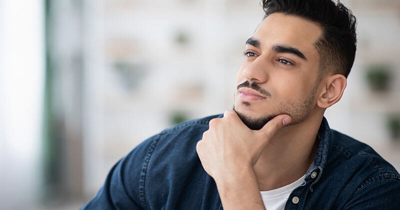 A younger man thinking which is a perfect example of cognitive patterns.