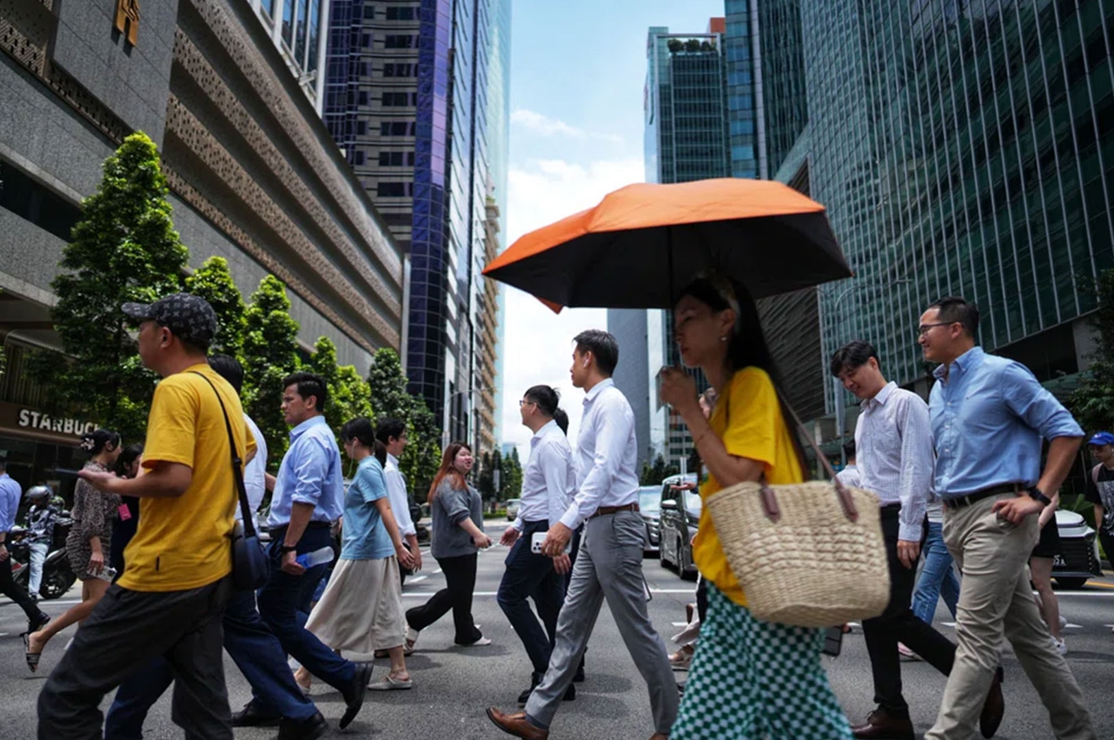 Professionals crossing a street in Singapore’s central business district.