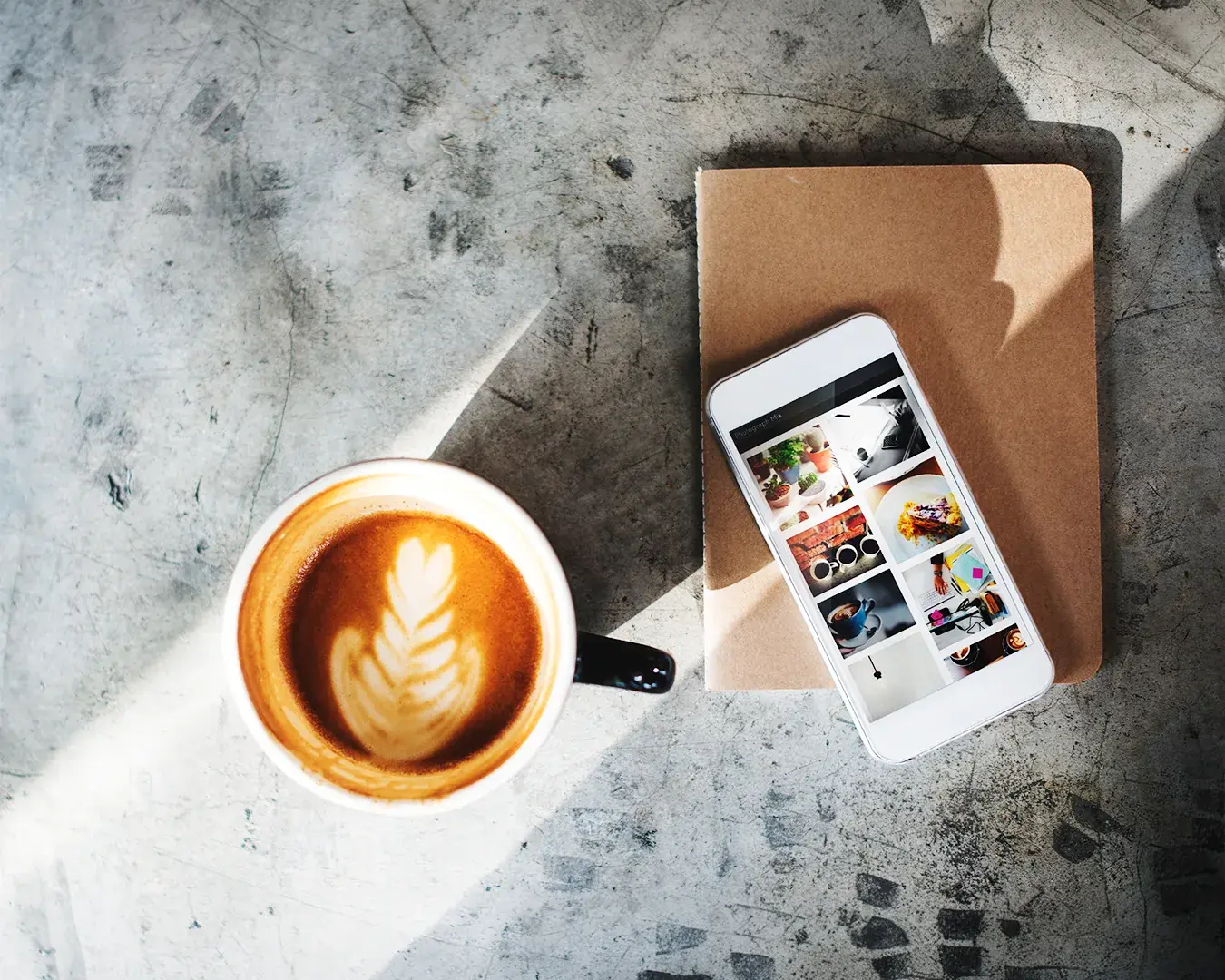 Coffee cup and smartphone displaying curated social media content in editorial workspace, symbolizing restaurant digital marketing strategy, customer engagement, and brand visibility.
