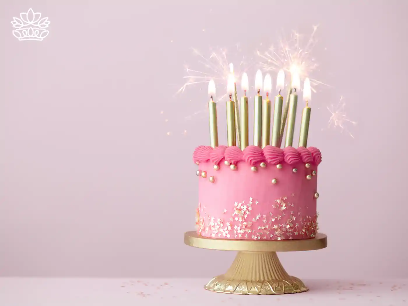 A beautifully decorated pink birthday cake with golden candles and sparklers, perfect for celebrating special occasions with style. Virgo Flowers & Gifts Collection. Fabulous Flowers and Gifts.
