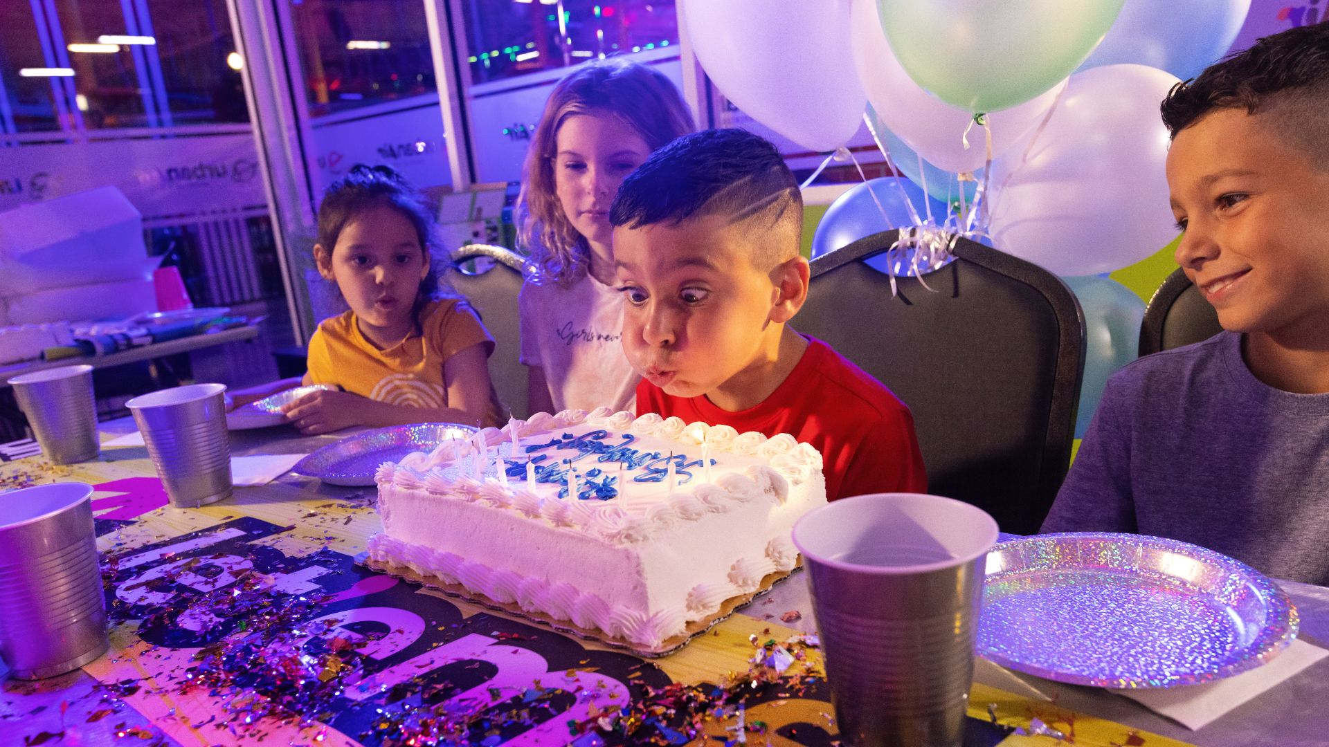 A 7-year-old blows out the candles at an awsome Urban Air birthday party. 