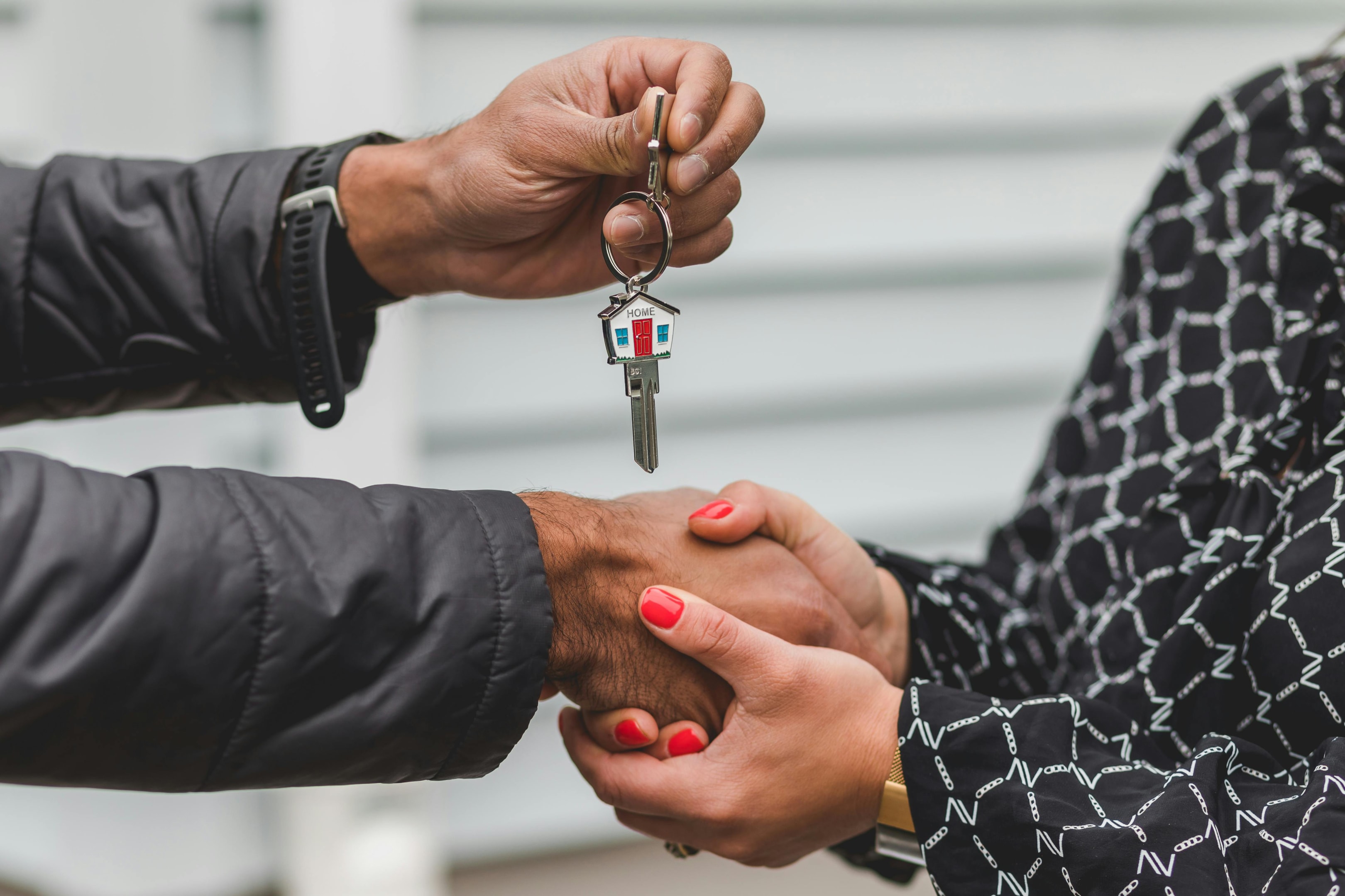 House key being passed from from home seller to real estate investor after successful lead nurturing.
