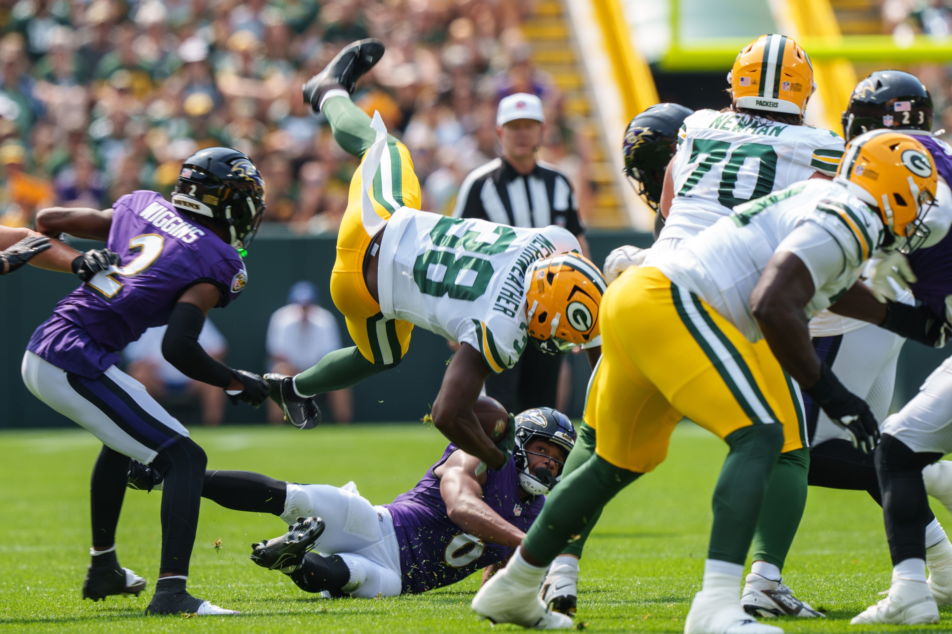 Ellis Merriweather of the Green Bay Packers gets upended during the first quarter of an NFL preseason football game against the Baltimore Ravens at Lambeau Field on August 24, 2024 in Green Bay, Wisconsin.