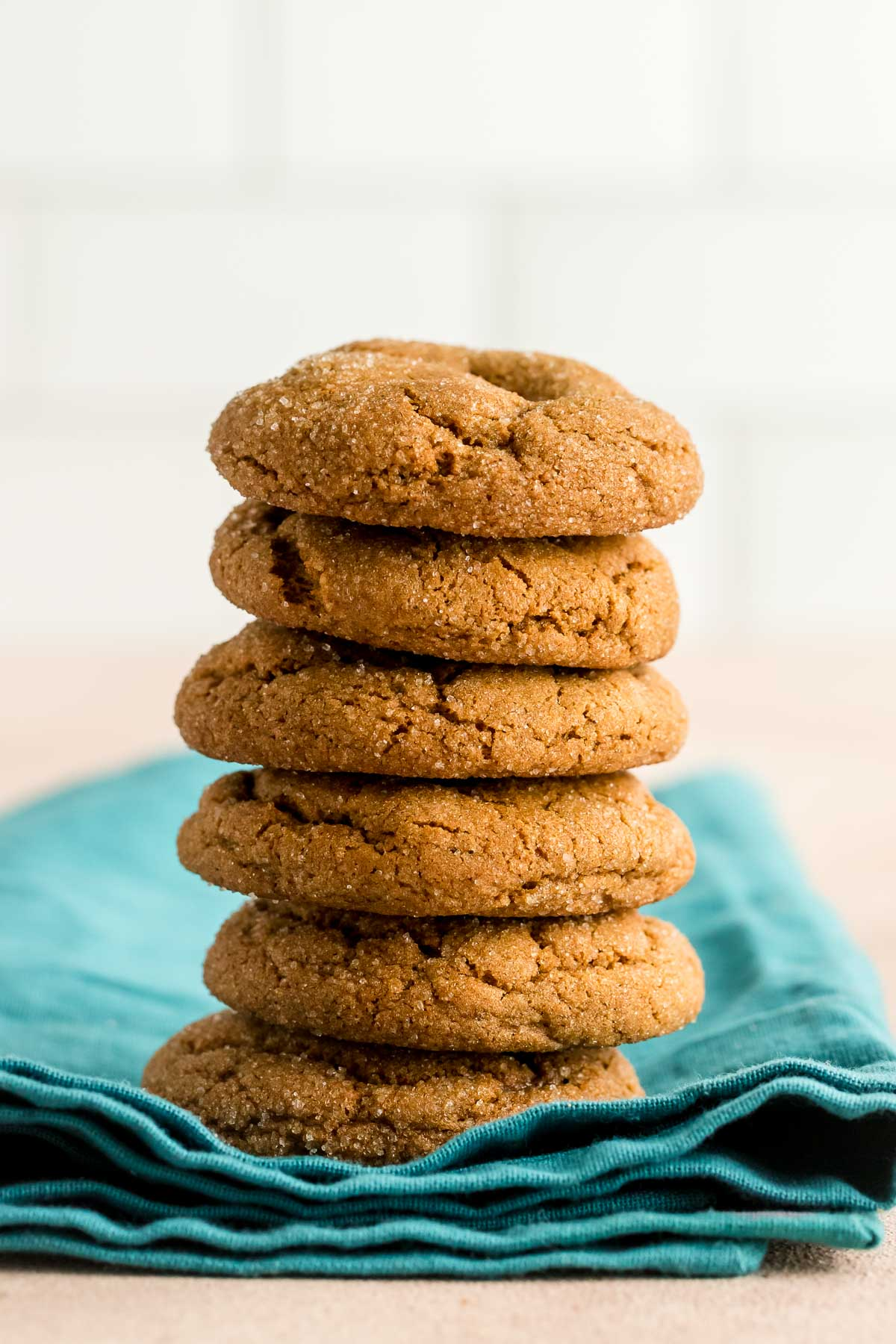 six molasses cookies stacked on a teal napkin