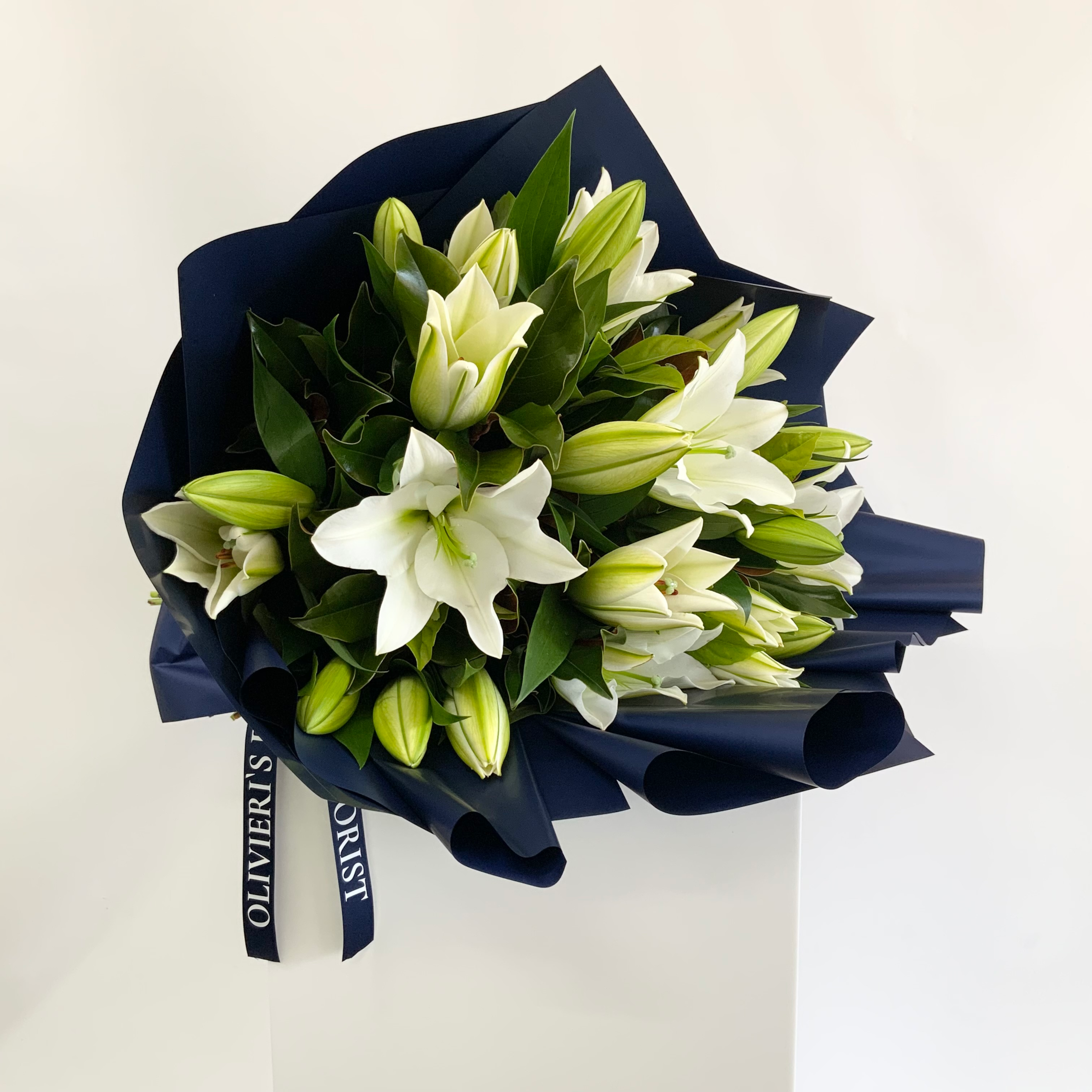 A florist arranging fresh flowers in a bouquet - olivieris florist
