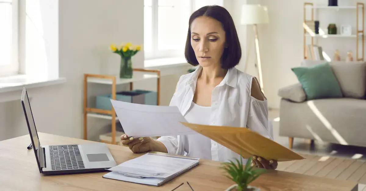 Woman reviewing IRS Notice CP30 with her tax return and estimated tax payment records.
