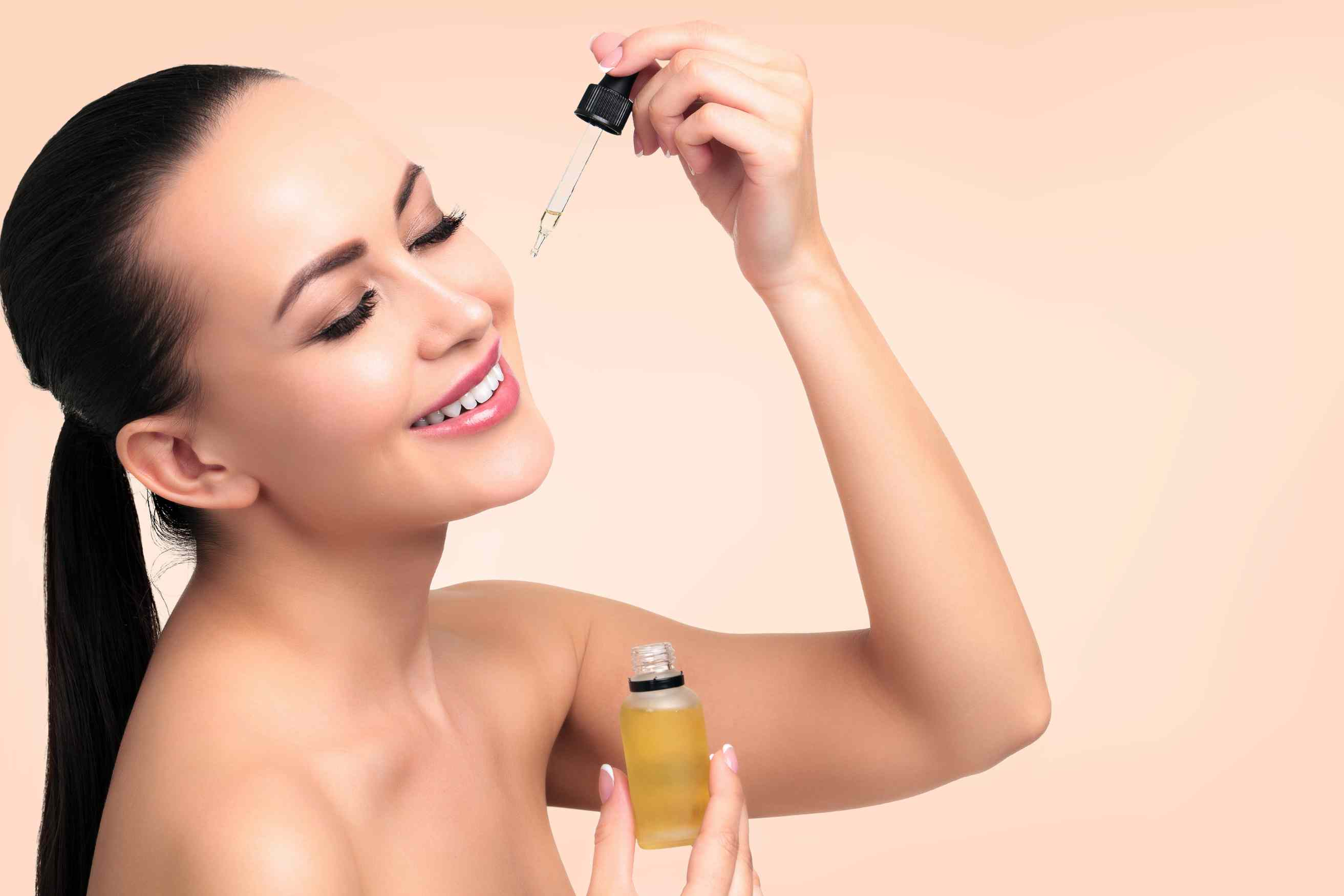 A woman applying tea tree oil to her face