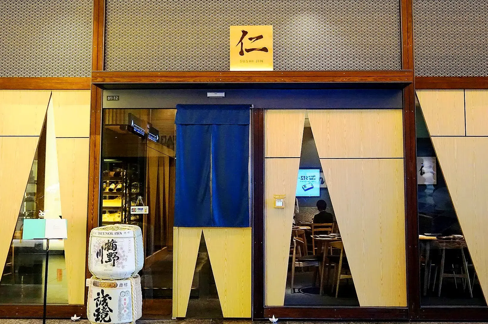 Sushi Jin Singapore Japanese restaurant entrance with traditional décor and sake display