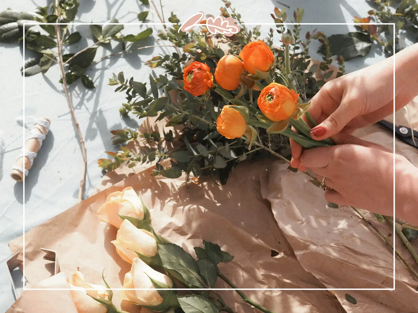 Hands arranging orange flowers on a table - Fabulous Flowers and Gifts