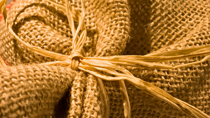 A close up of a jute burlap sack tied with twine