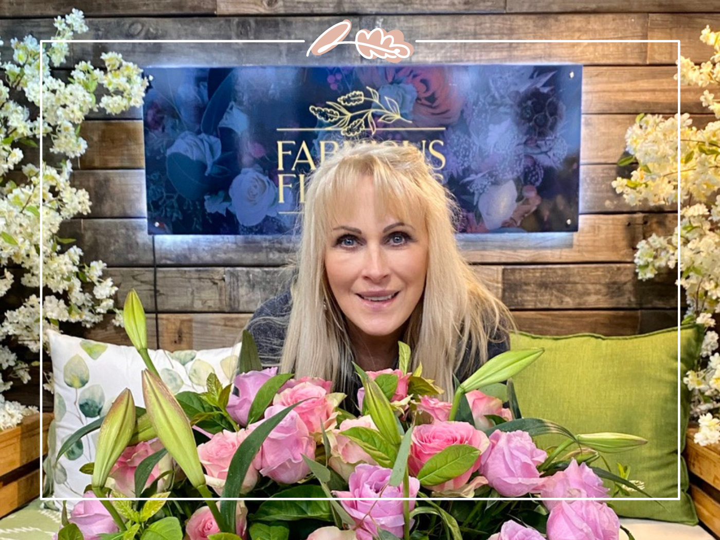 A smiling florist surrounded by beautiful pink flowers at Bunches for Africa in the Western Cape store, demonstrating their expertise in creating stunning floral arrangements for any occasion. Available at Fabulous Flowers and Gifts.