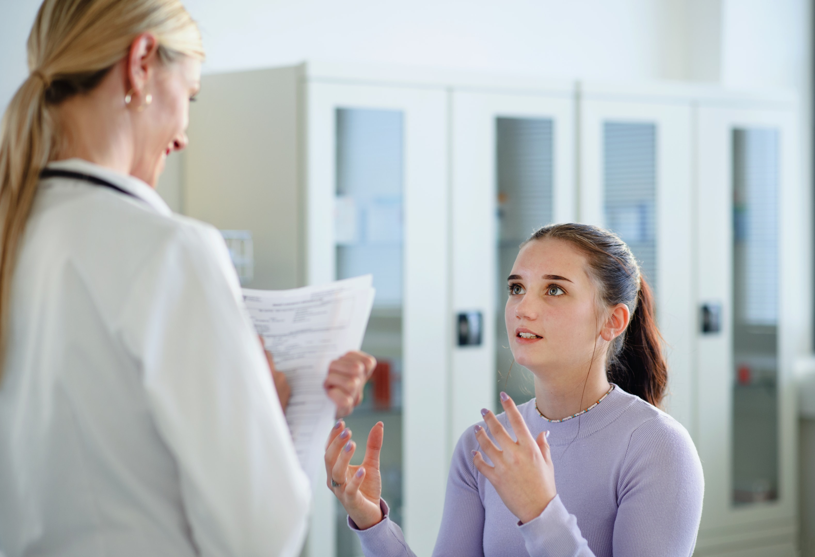 Teenager talking to doctor about the consequences of wisdom tooth removal without anesthesia