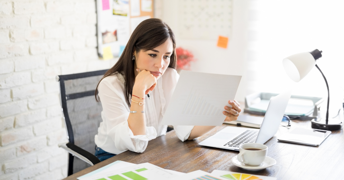OnlyFans creator reviewing business finances and preparing her S corporation tax return at a modern desk with a laptop and organized paper work.