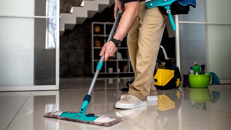 A man using a microfiber mop on the hotel floor