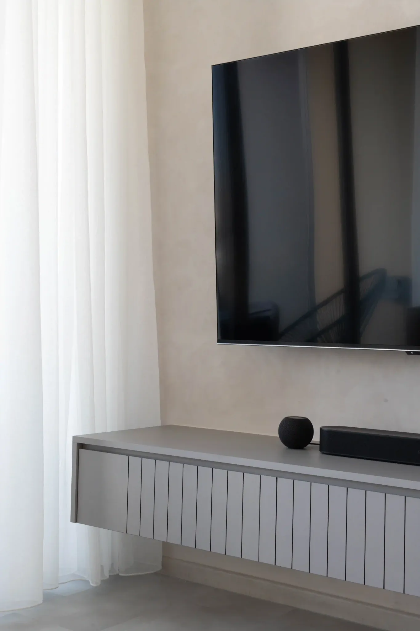 Floating TV console and wall-mounted screen with sheer curtains for a clutter-free 4-room HDB living room.