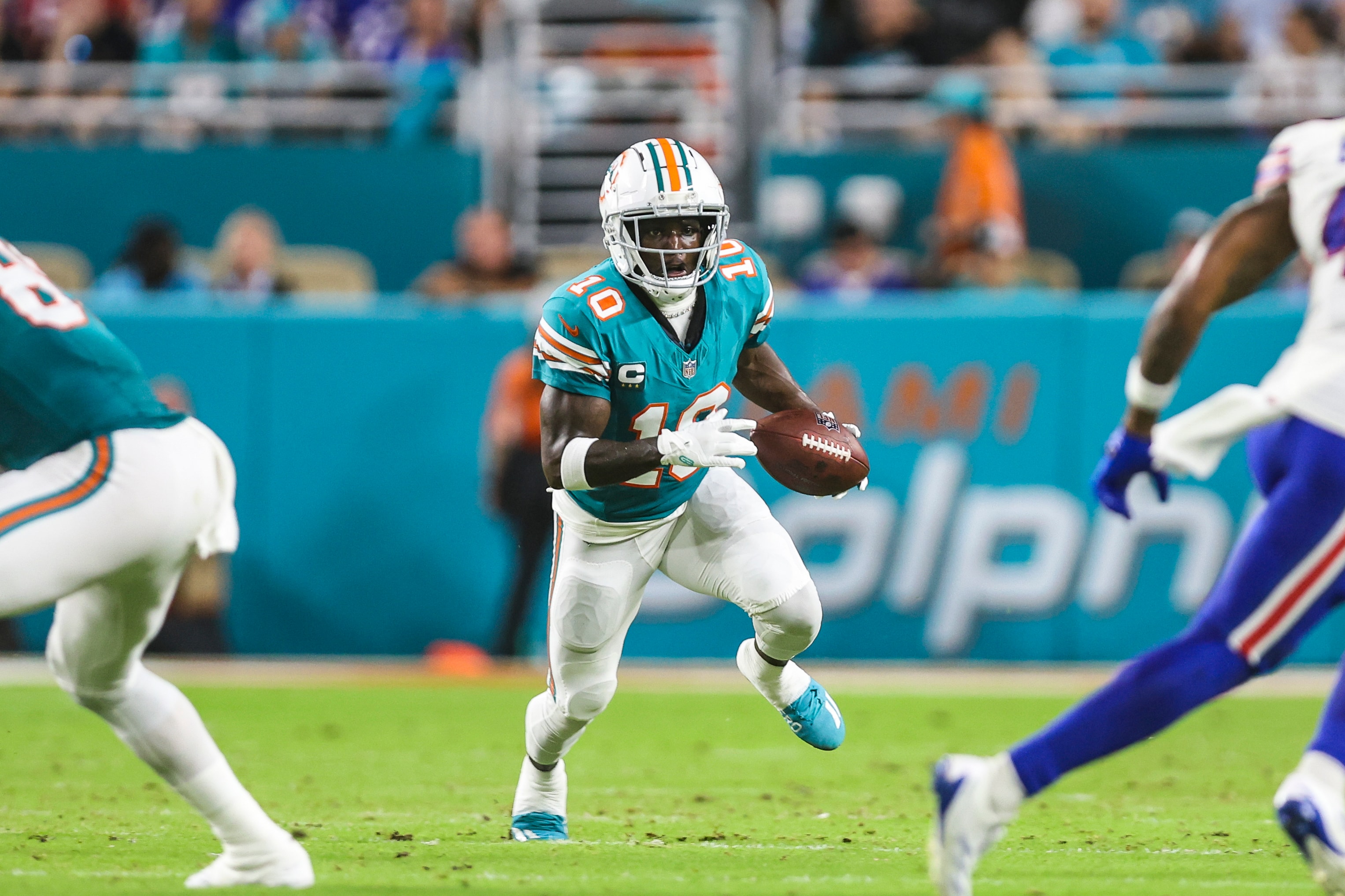 Tyreek Hill of the Miami Dolphins runs the ball during an NFL football game against the Buffalo Bills at Hard Rock Stadium on September 12, 2024 in Miami Gardens, FL.