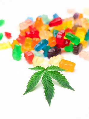 A person holding a bottle of 10mg CBD gummies with a label showing the quality of ingredients