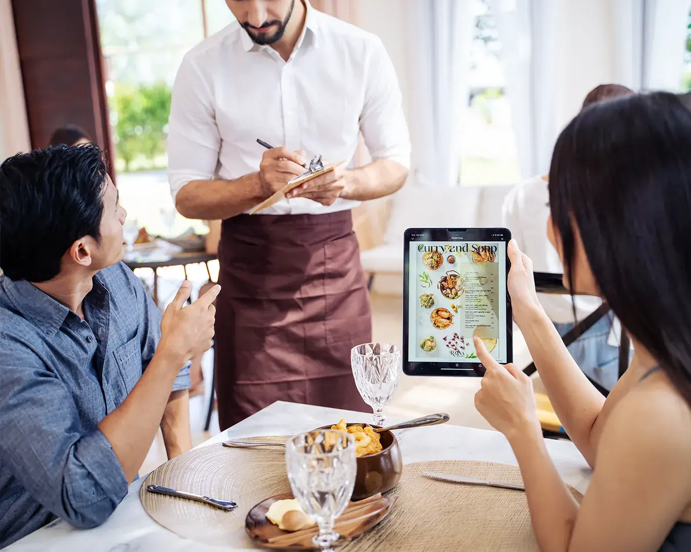 Restaurant guests using a digital QR code menu while ordering with server assistance, improving customer experience and operational efficiency.