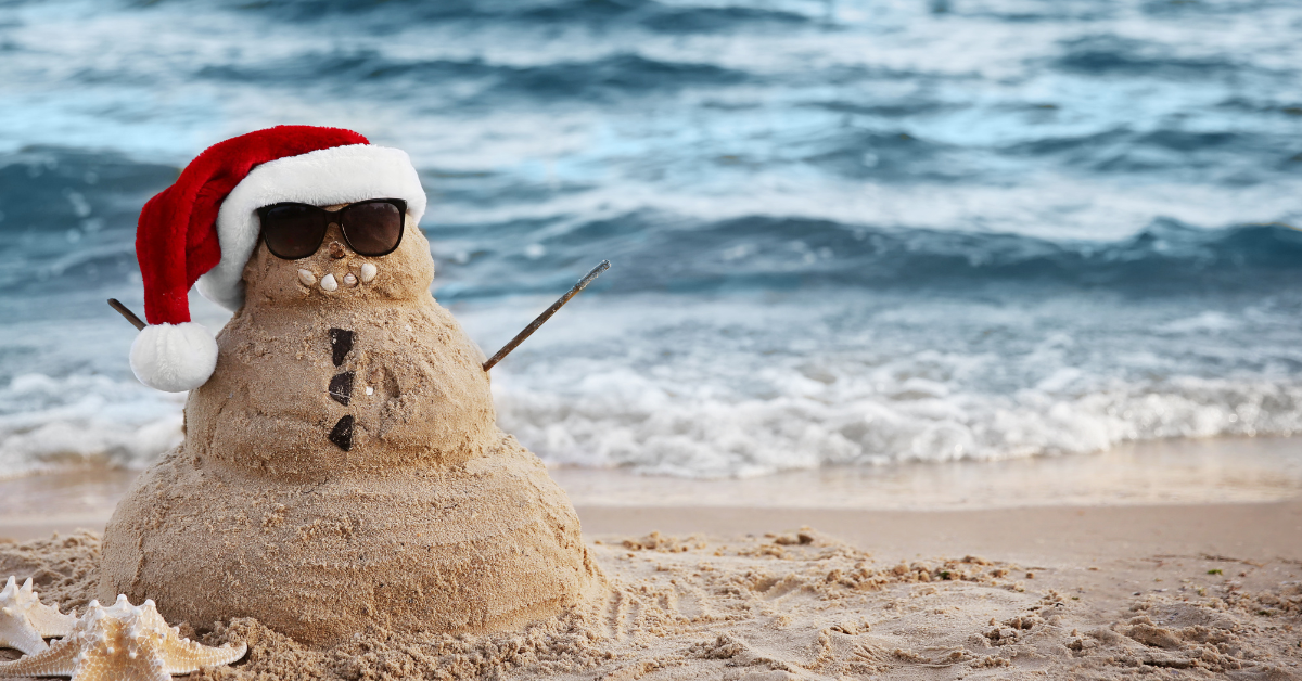 Sand snowman wearing a Santa hat and sunglasses on a Jersey Shore beach, capturing the fun of Christmas in NJ with coastal holiday vibes and family-friendly seaside festivities.