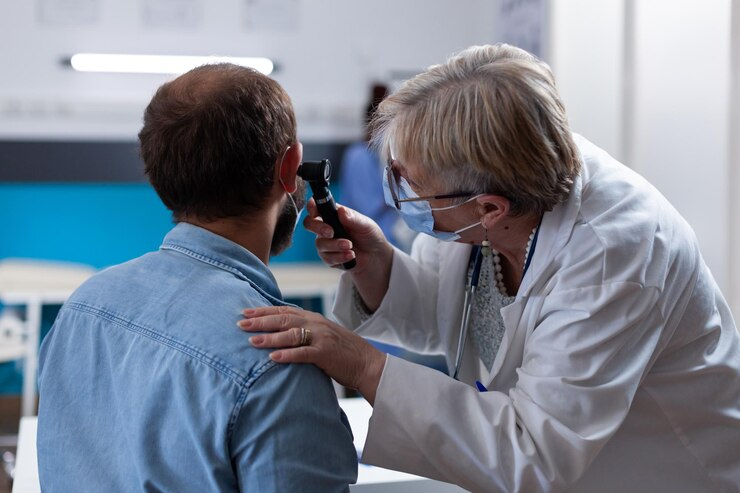 Ear doctor examining patient's ear