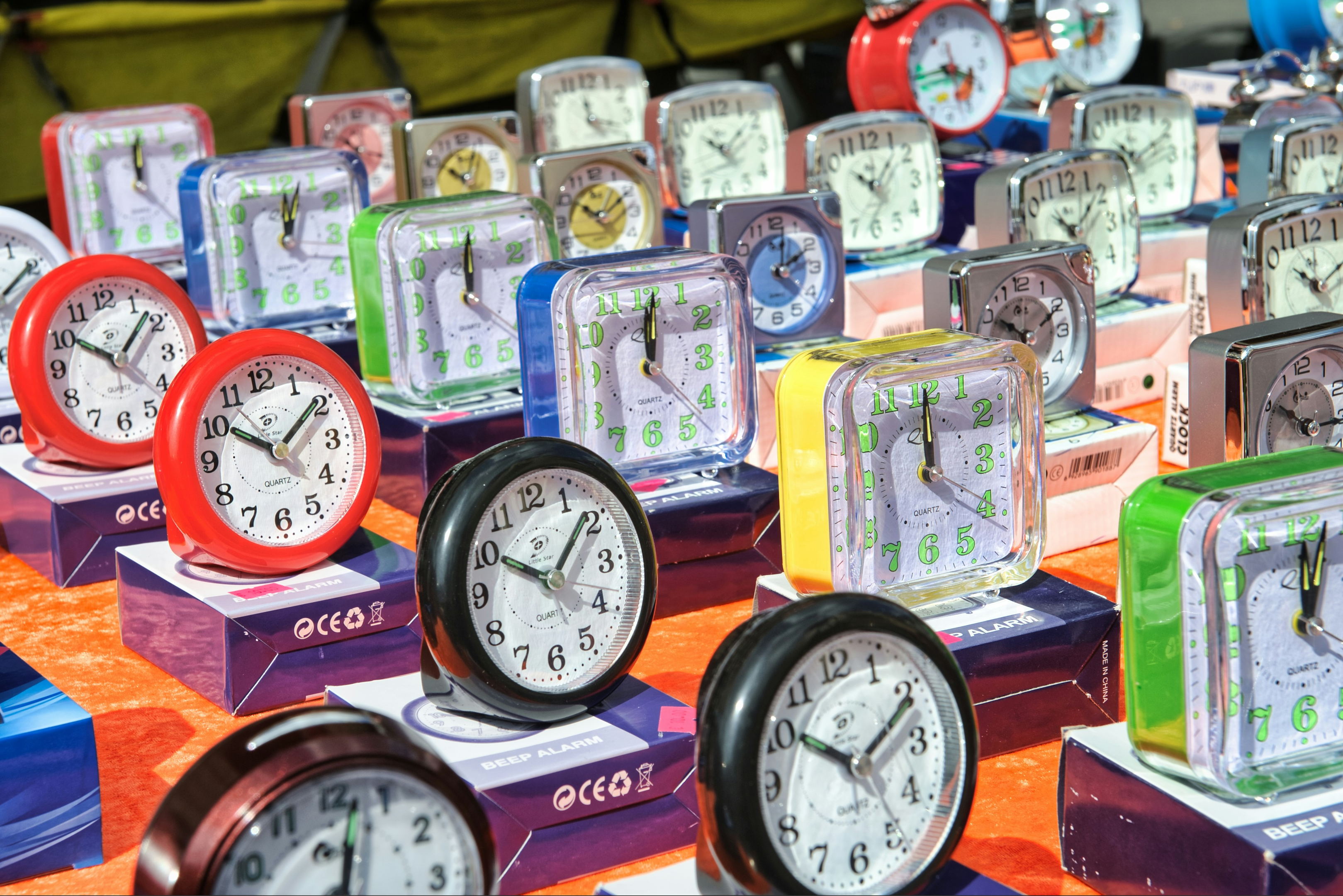 A lot of colorful analog clocks