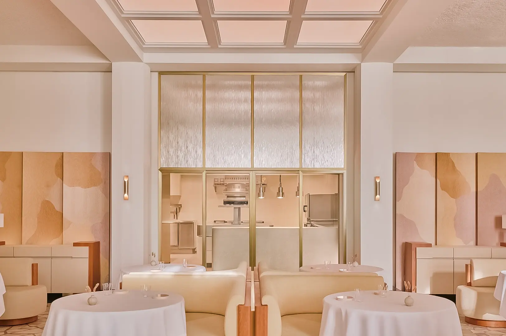 Symmetrical eye‑level wide shot of an elegant fine‑dining restaurant interior, featuring round white tablecloth tables, soft neutral tones, and an open kitchen framed by glass panels.