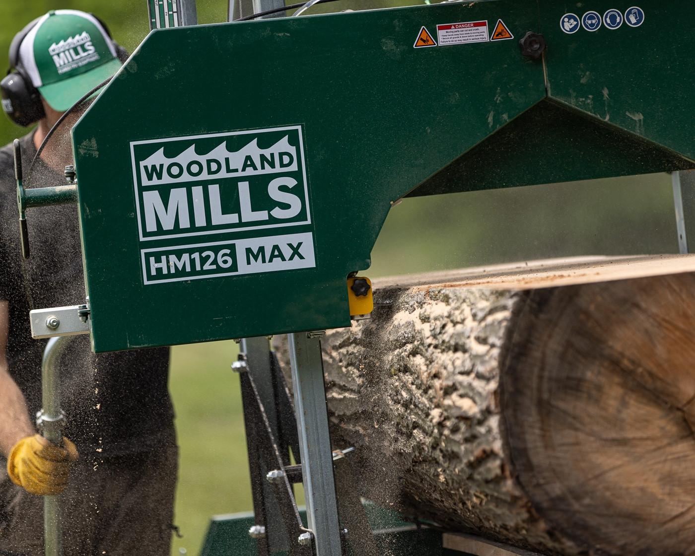 The Woodland Mills HM126MAX Portable Sawmill cutting into a log.