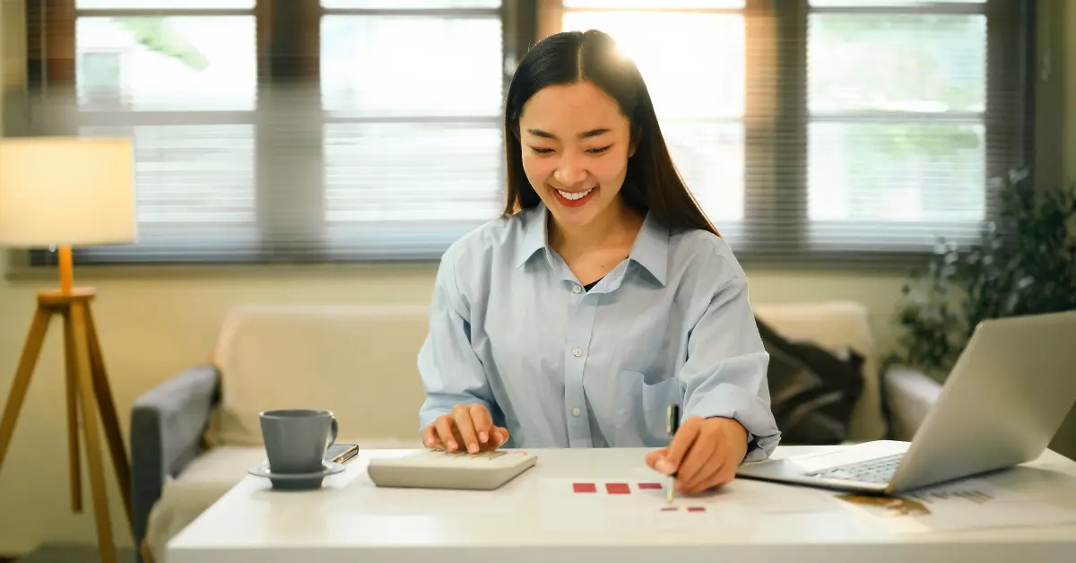 Woman reviewing earnings on her work table comparing net pay vs gross pay for OnlyFans income.