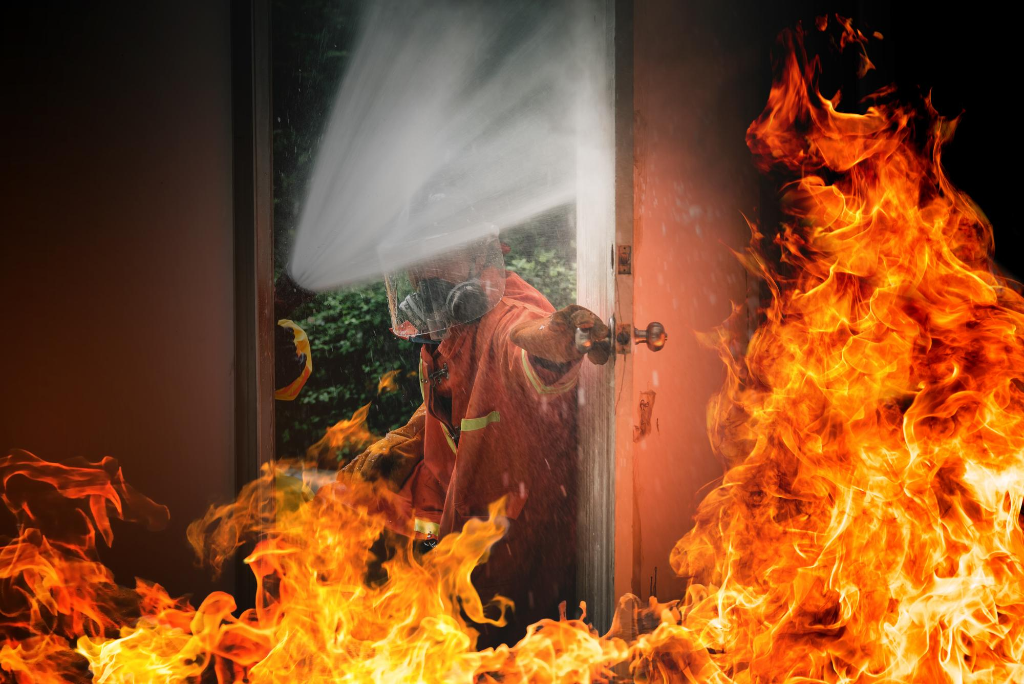 A firefighter putting out fire at a house