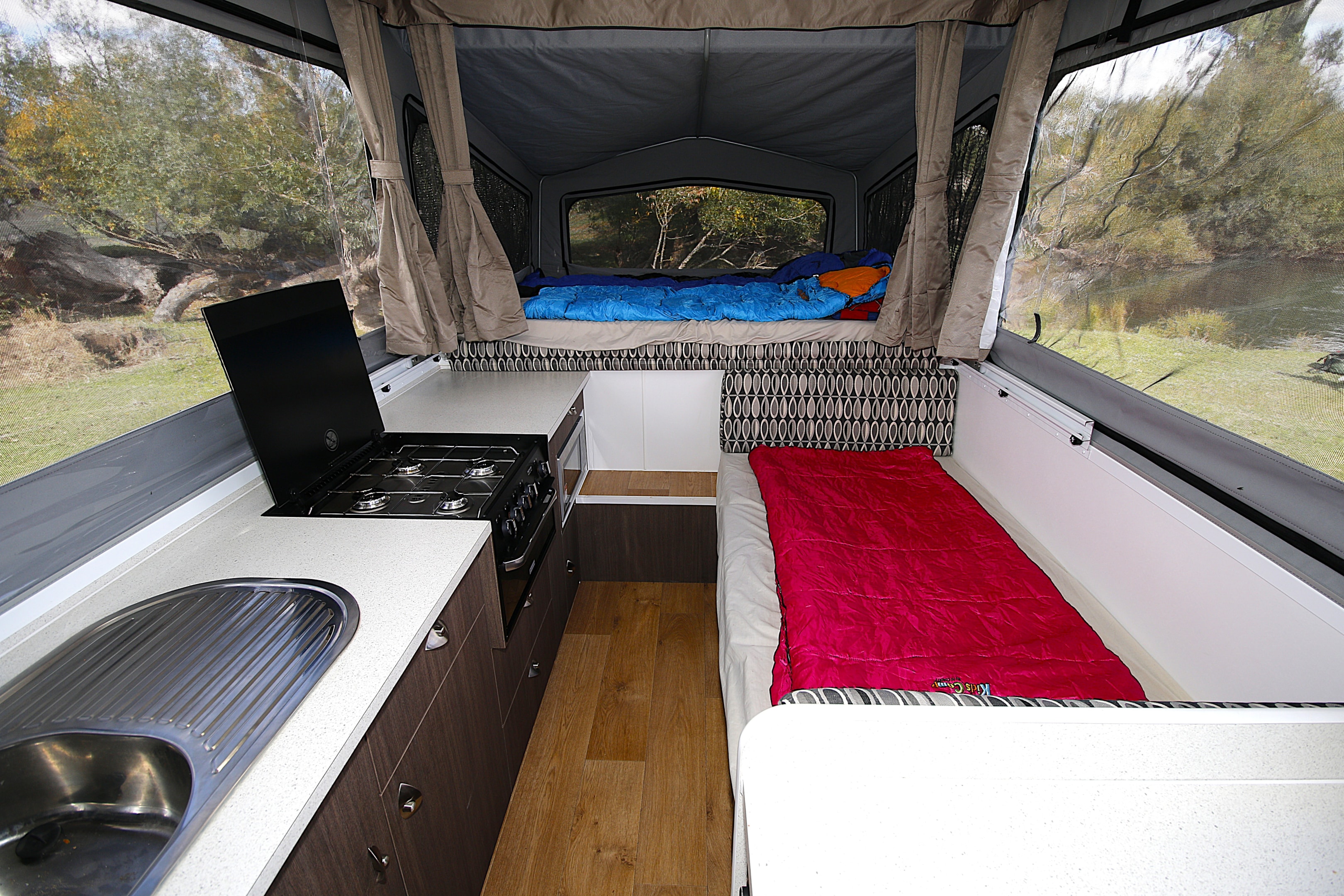Pop top campers offer low travel height for overhanging bush and storage.