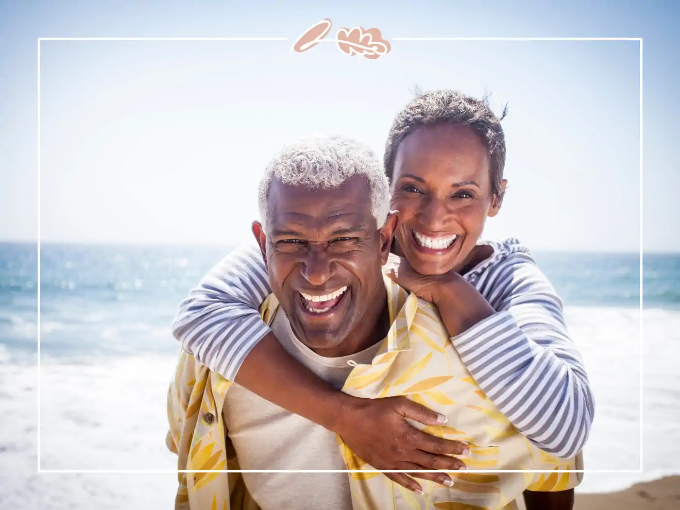 A joyful older couple enjoying a piggyback ride on the beach, both smiling brightly. Fabulous Flowers and Gifts.