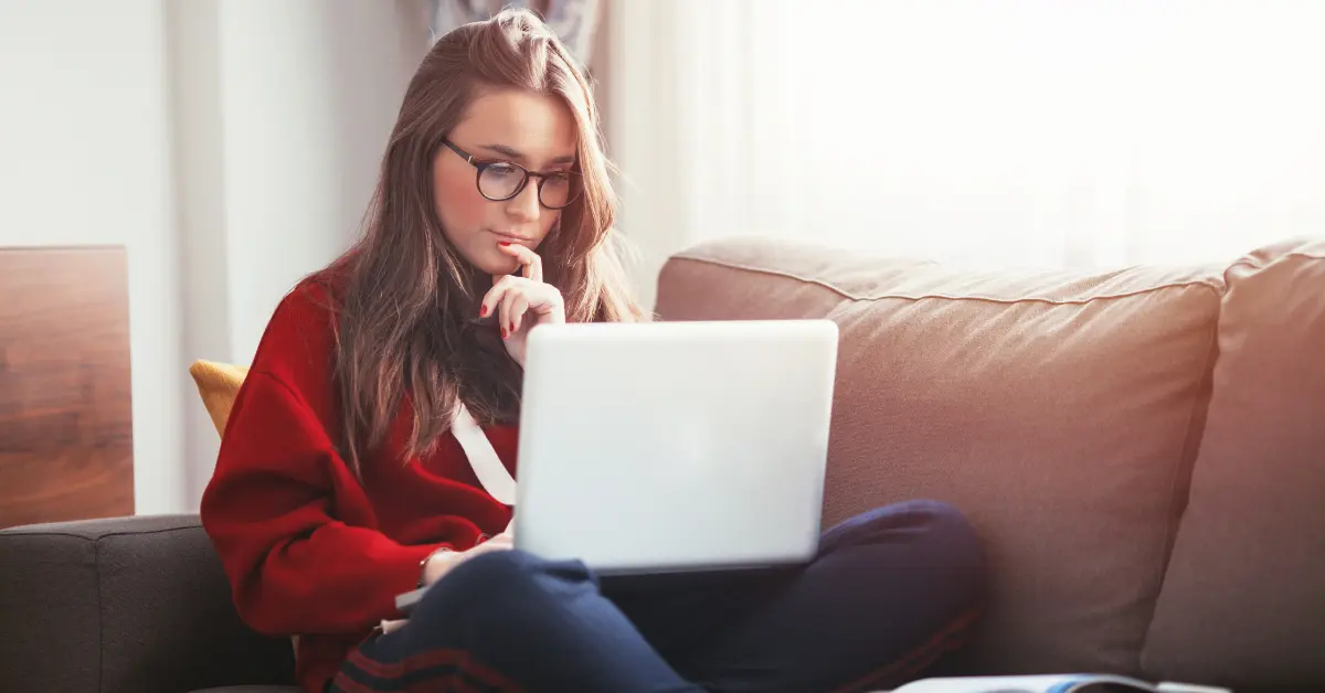 Female creator using a laptop to look up OnlyFans address for taxes.