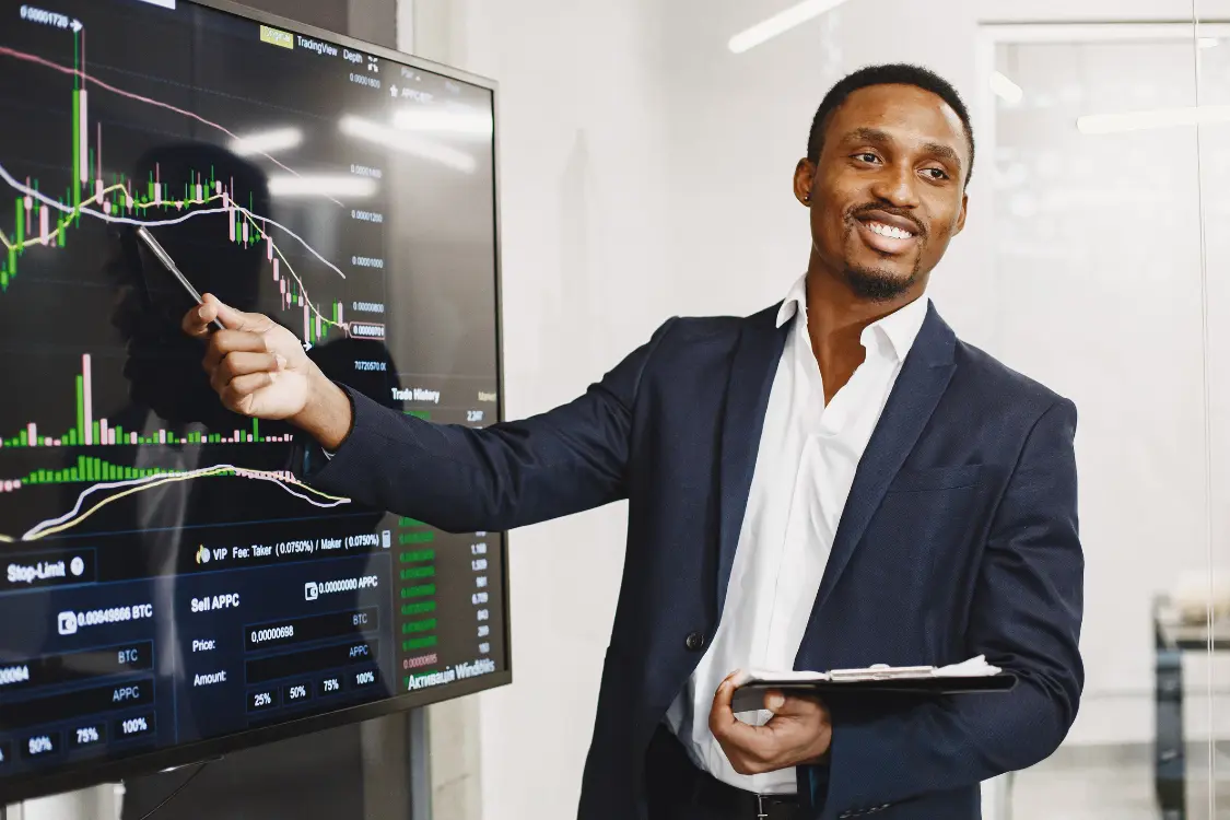 Broker explaining market data on a digital trading screen