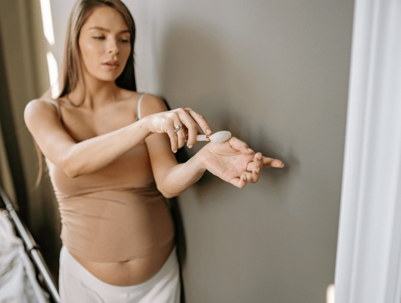 Pregnant woman doing skincare