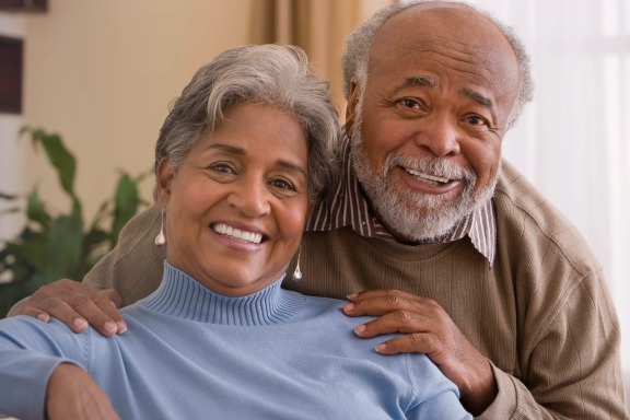 Smiling senior couple showing how dental implants Calgary can restore your smile