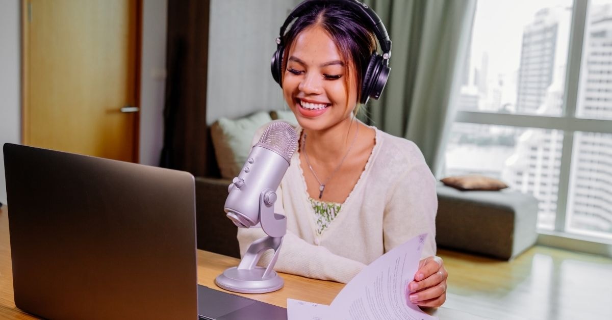 A smiling content creator recording with a microphone, preparing to discuss OnlyFans tax forms and financial tips.