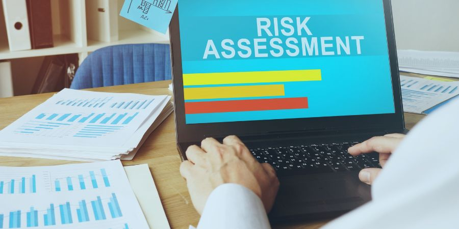 Graphs on a desk and laptop showing a risk assessment