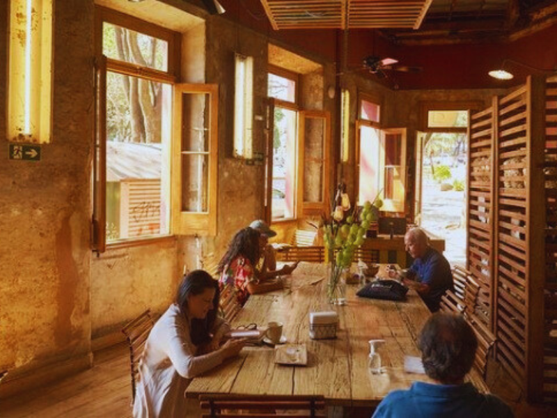 Clientes sentados à mesa em casarão com janelas amplas. Imagem: Reprodução Instagram. 