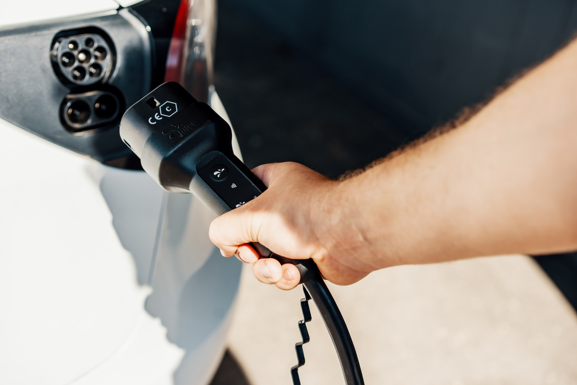 Man plugging a Mode 3 charging cable into an electric vehicle.