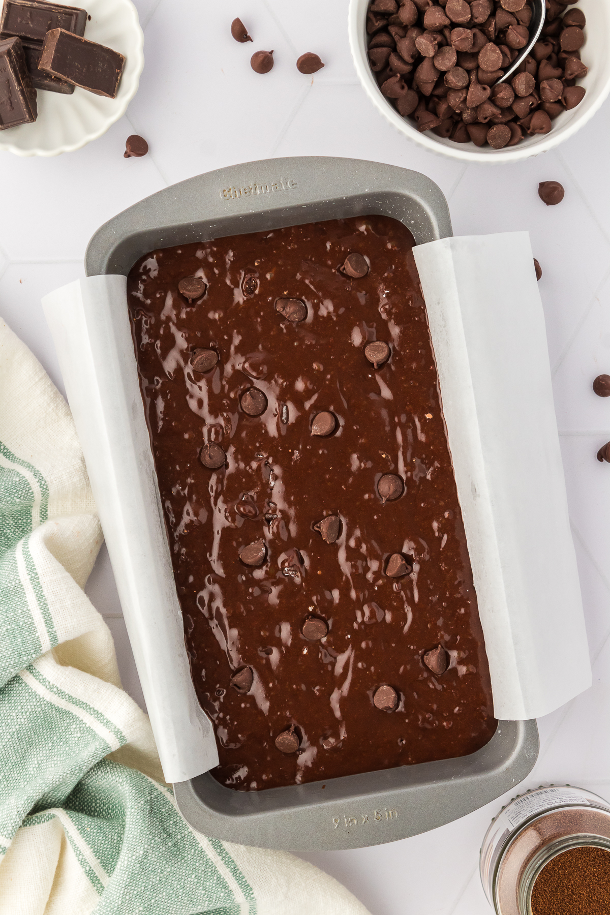 chocolate bread batter in loaf pan lined with parchment paper