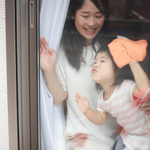 mother and daughter cleaning a window