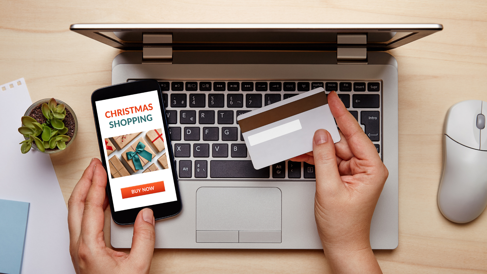 Para cego ver: Pessoa comprando usando o cartão de crédito na loja do instagram um presente de natal. Atrás da mão da pessoa tem um Macbook M1 em cima de uma mesa de madeira. 