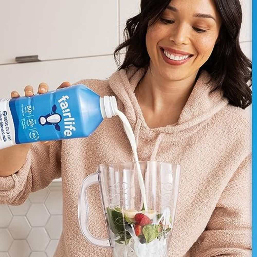 A person drinking a protein shake and smiling