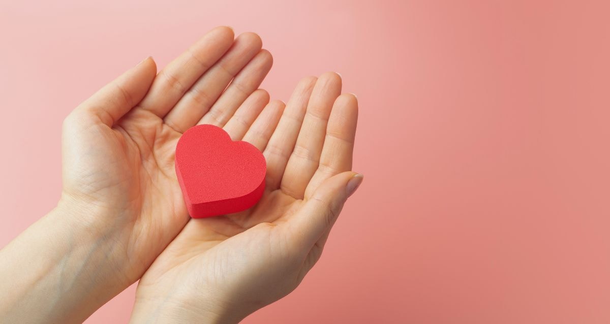 Intended parent holding a red heart symbolizing their want for a baby