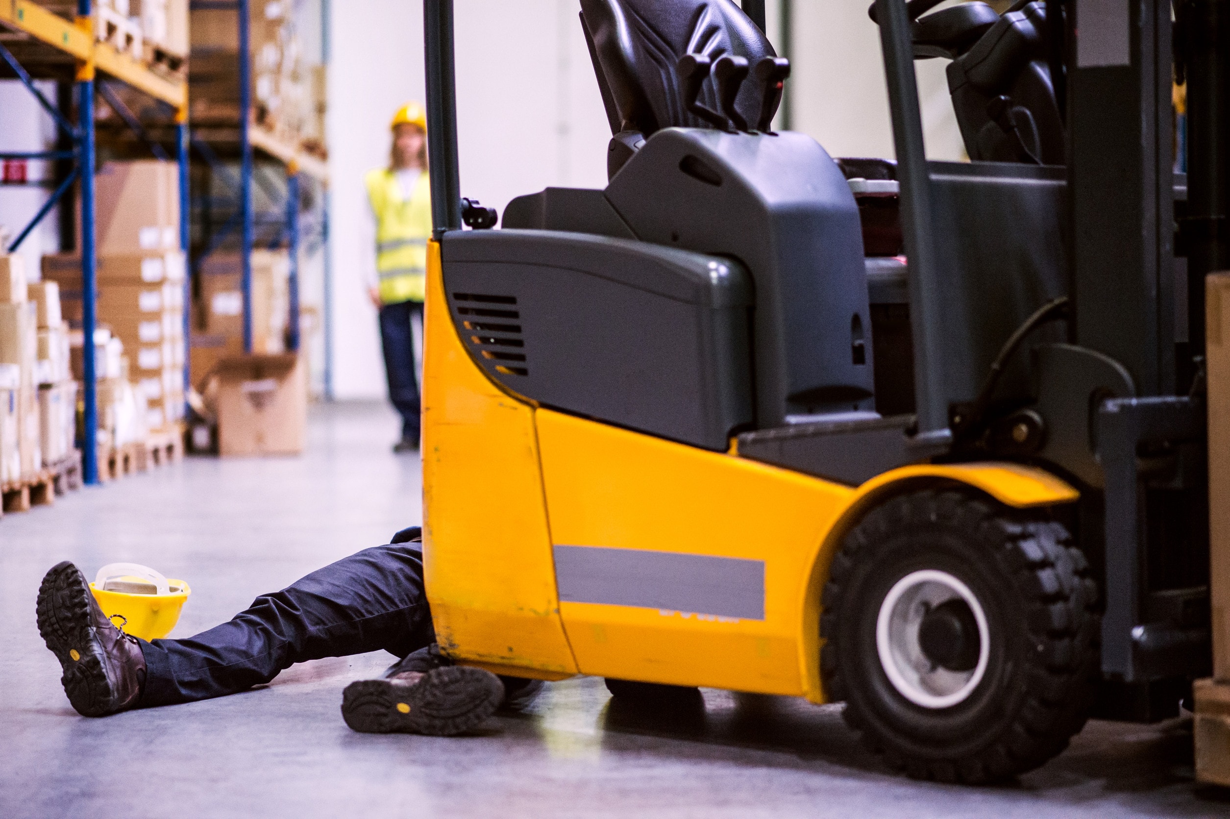A man lays on the floor with serious injuries sustained after being hit by a forklift