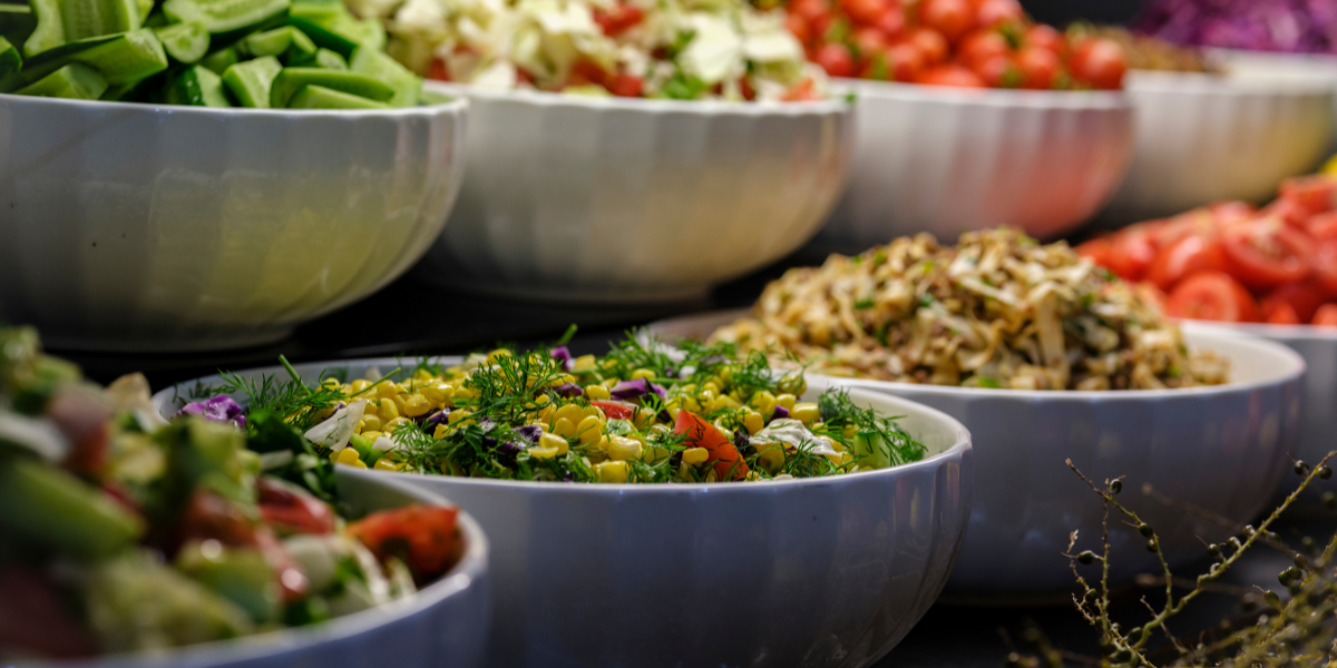 two rows of bowls filled with vegetables and mixed salads to maintain good nutrition