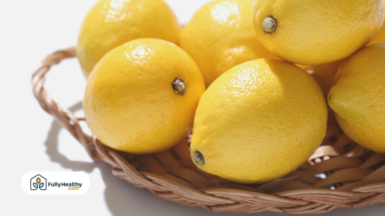 Wicker basket filled with bright yellow lemons under natural sunlight