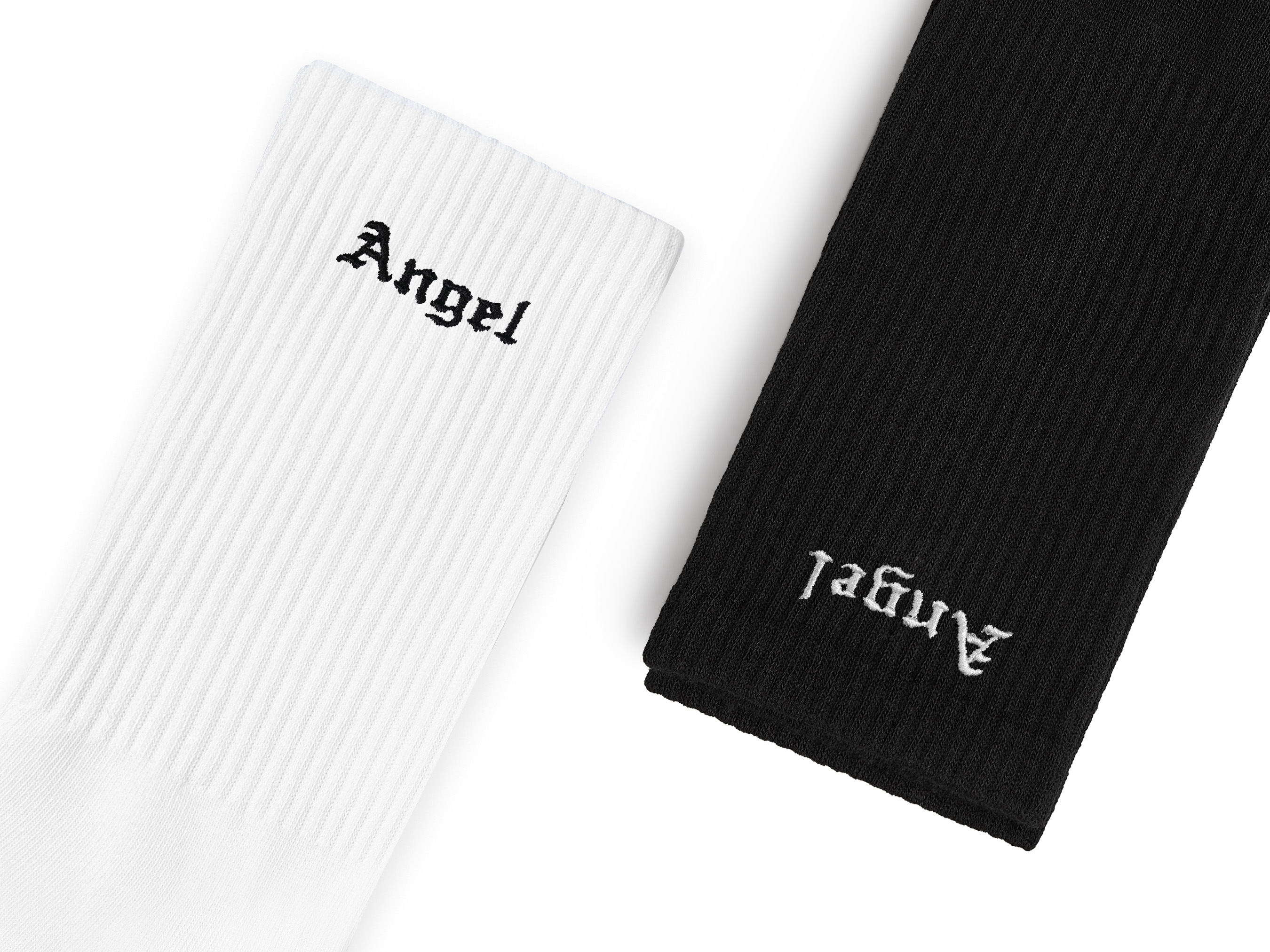 A flat-lay image of custom women white and black crew socks with 'Angels' text embroidered on them.