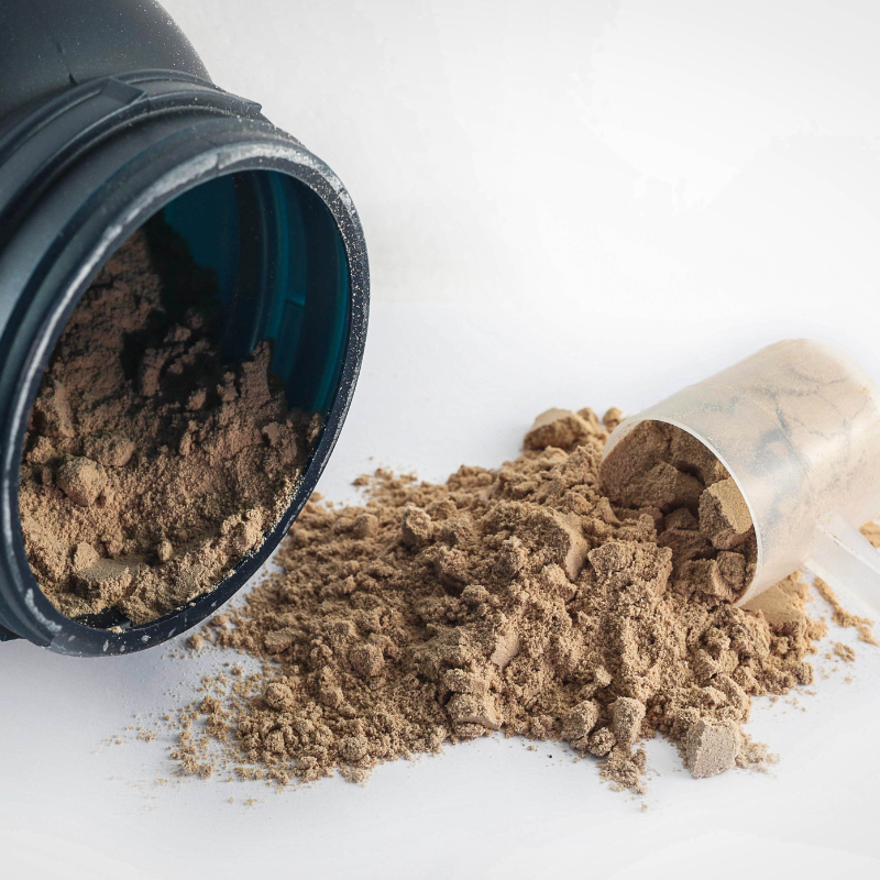 Image of protein powder coming from the bottle.